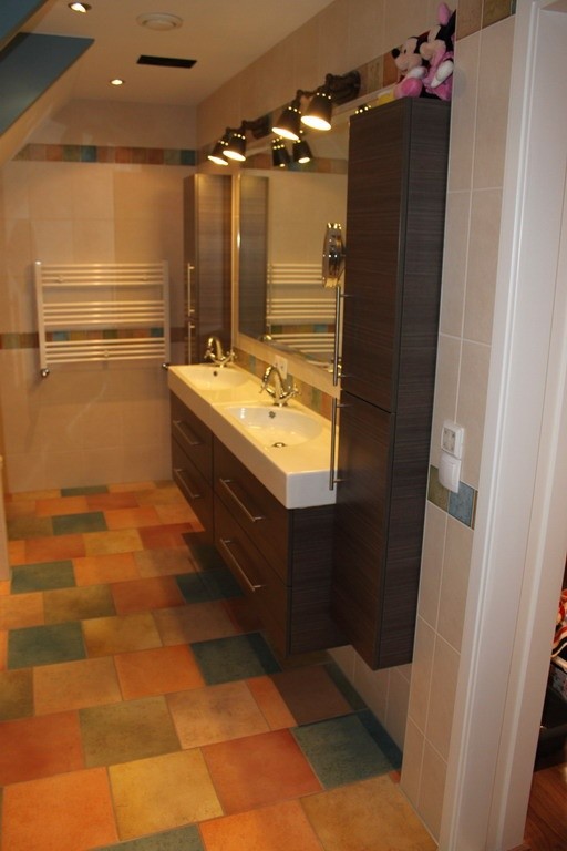 Kleurrijk betegelde badkamer met dubbele wasbak
