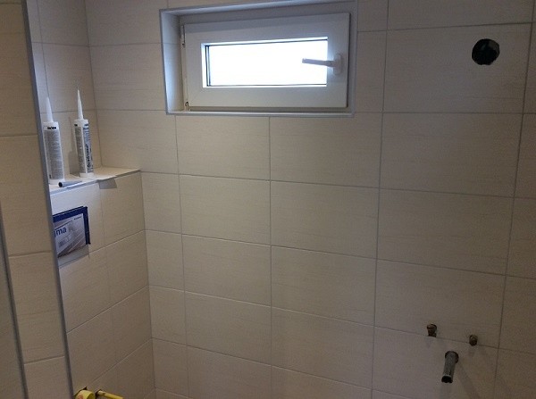 Moderne beige badkamer met klein raam